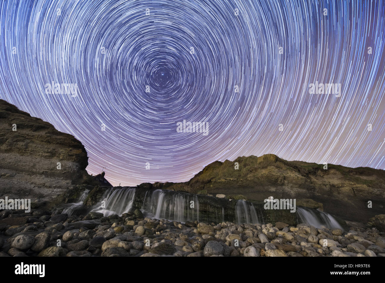 Night Sky Star Trails over Osmington Mills, Dorset Stock Photo