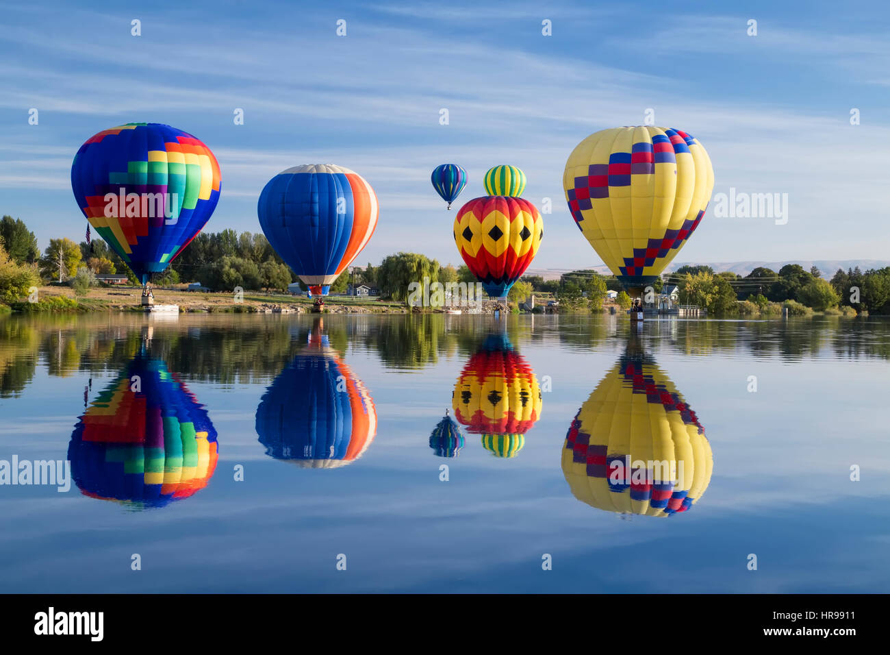 Hot Air Balloons touching down on the water with reflection Stock Photo