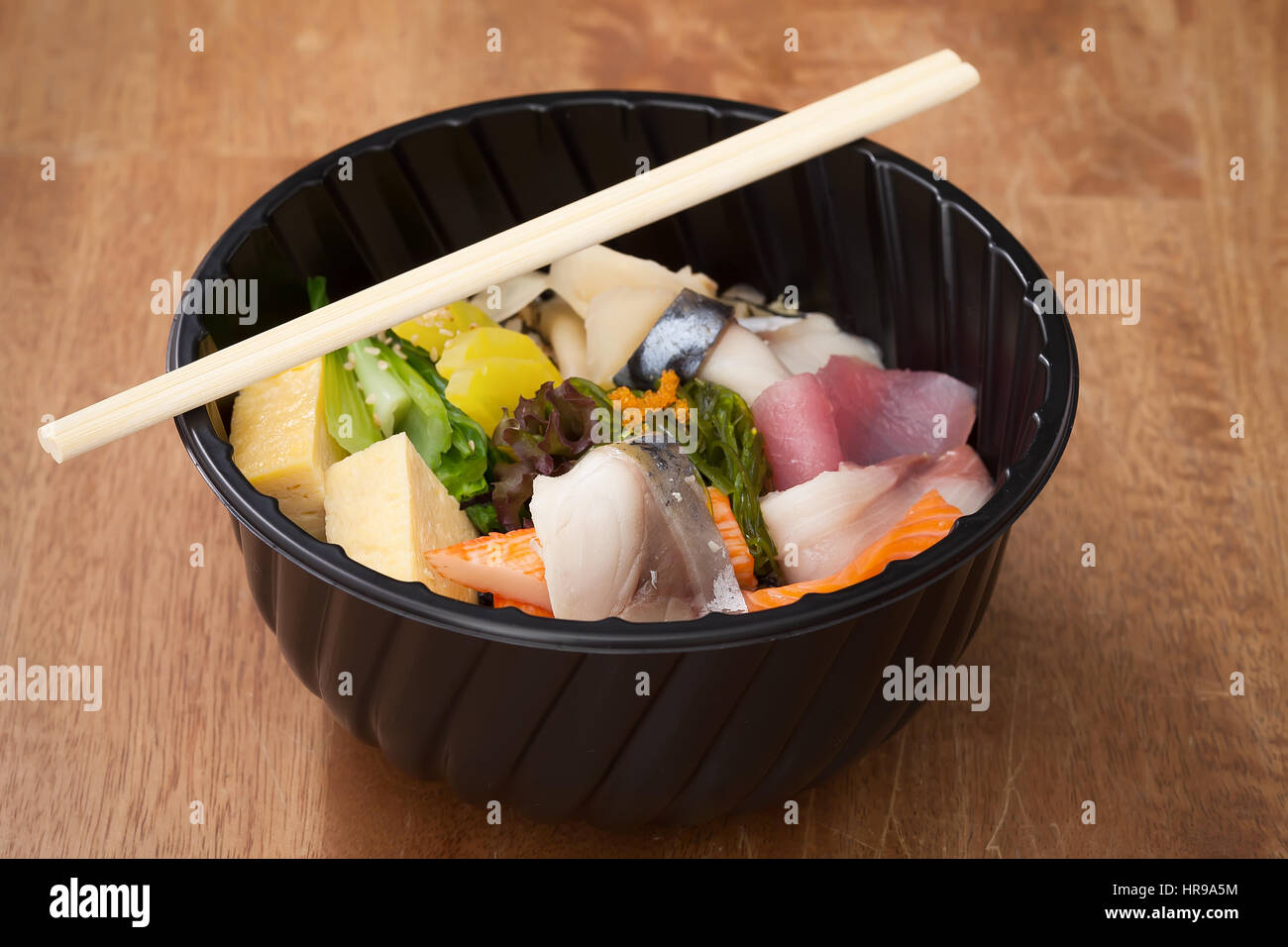 Japanese food Tekka Don take away on wooden background raw tuna salmon otoro seaweed rice Stock