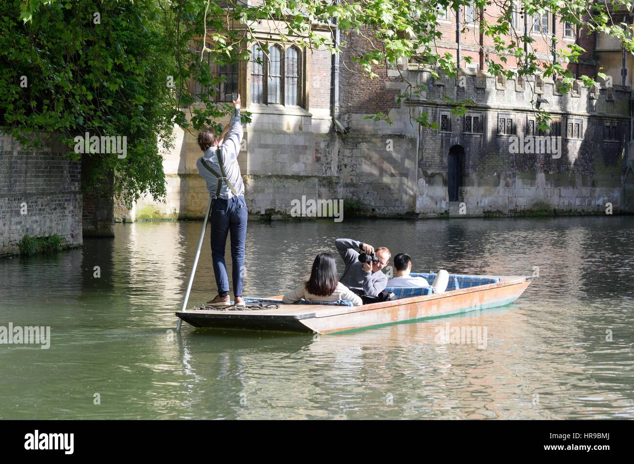 Cambridge England, United Kingdom -May 20, 2016: Punter guiding boat of   tourists on Cam Cambridge England Stock Photo