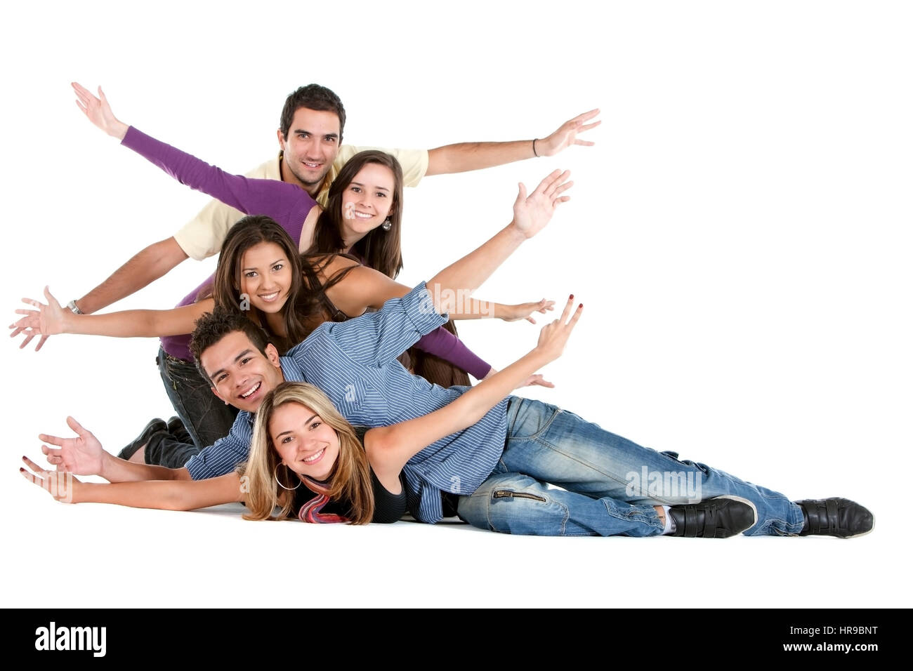 Happy group of friends on the floor with their arms up isolated over a ...