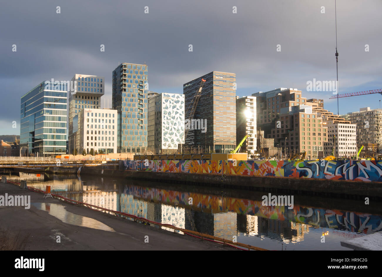 The skyline of Oslo Norway is steadily developing as the construction works in Bjørvika Barcode neighbourhood downtown  progress, winter and low sun Stock Photo