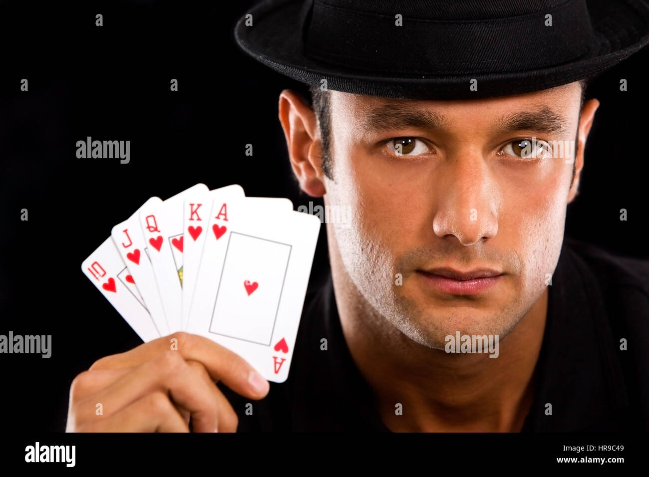 man with Royal Flush Poker Hand - isolated over a black background Stock Photo