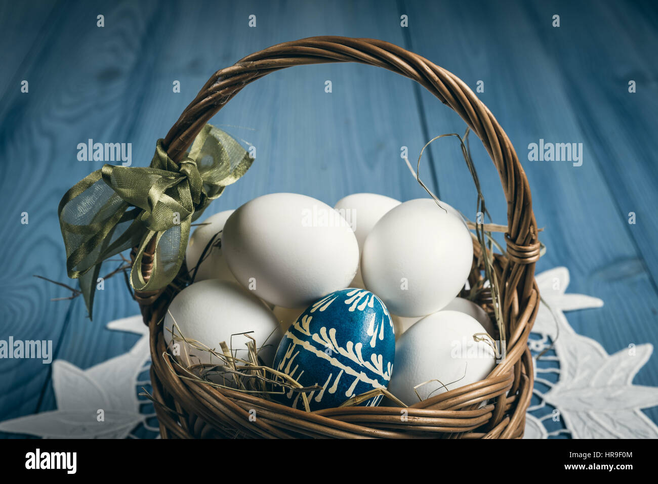 Group of eggs in the basket on the blue wooden surface. Easter concept. Stock Photo