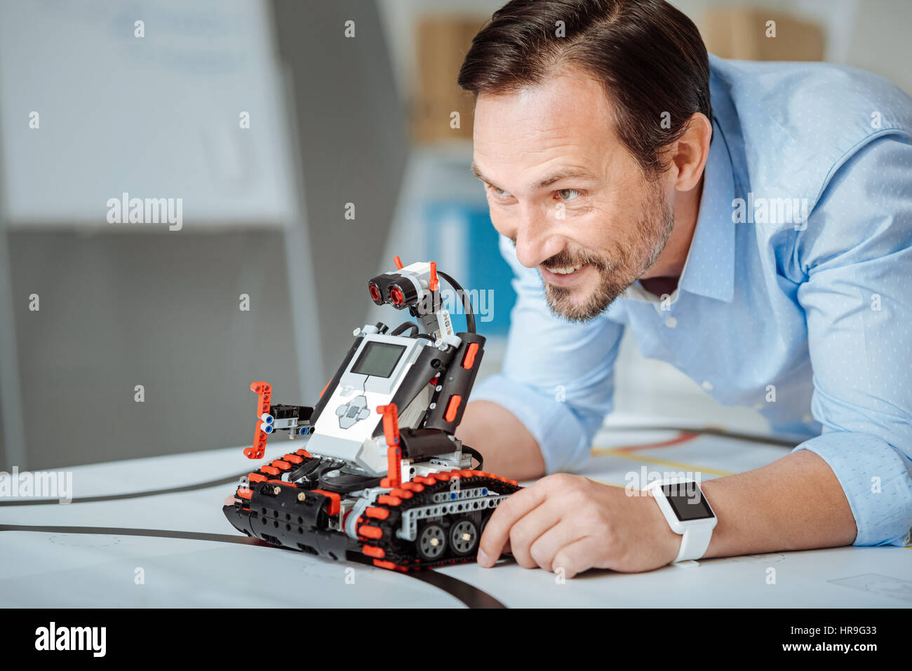 Cheerful engineer testing the robot Stock Photo - Alamy