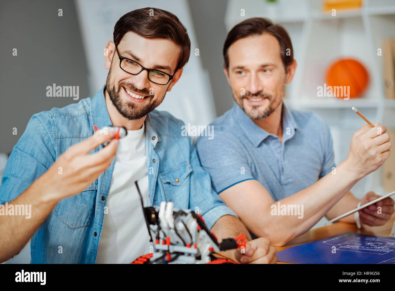 Positive engineers testing robot Stock Photo - Alamy