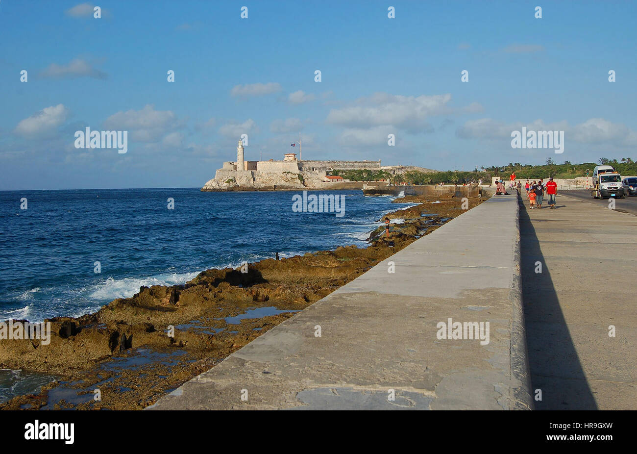The Malecon, the promenade and sea wall, with Castillo del Morro in the background.  City of Havana, Cuba Stock Photo