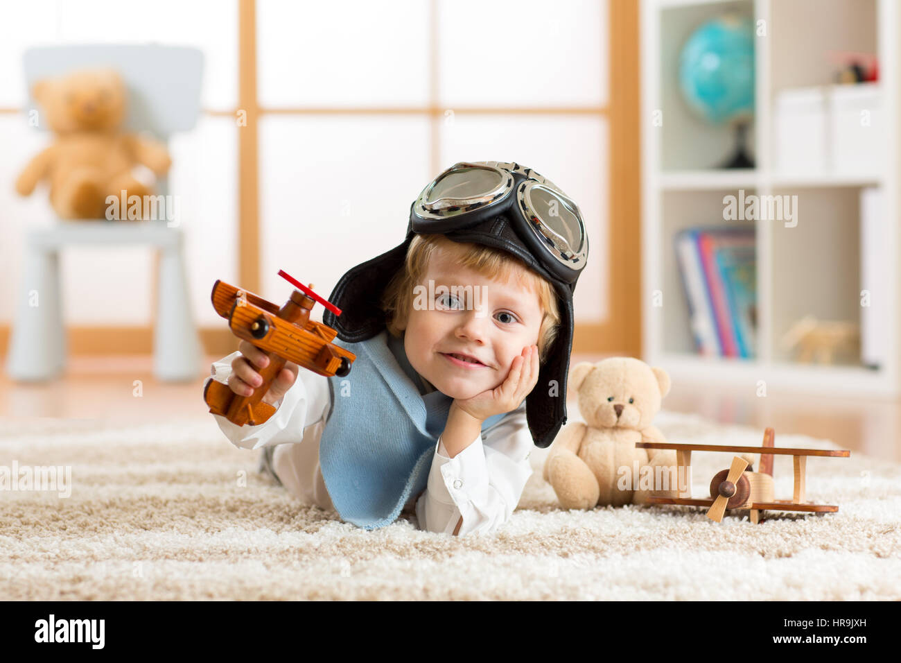 portrait of little boy playing with wooden airplane Stock Photo