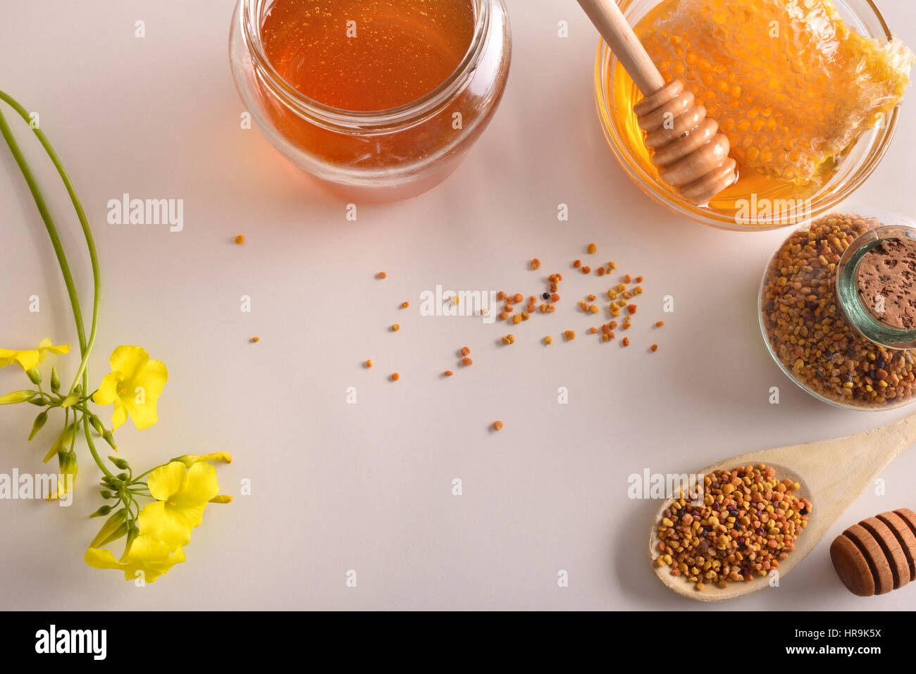 Containers with honey, honeycomb and pollen bee. Decoration with flowers and pollen grains. Top view. Horizontal composition Stock Photo