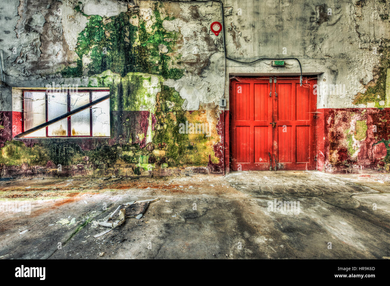 Red wooden door inside a derelict warehouse Stock Photo