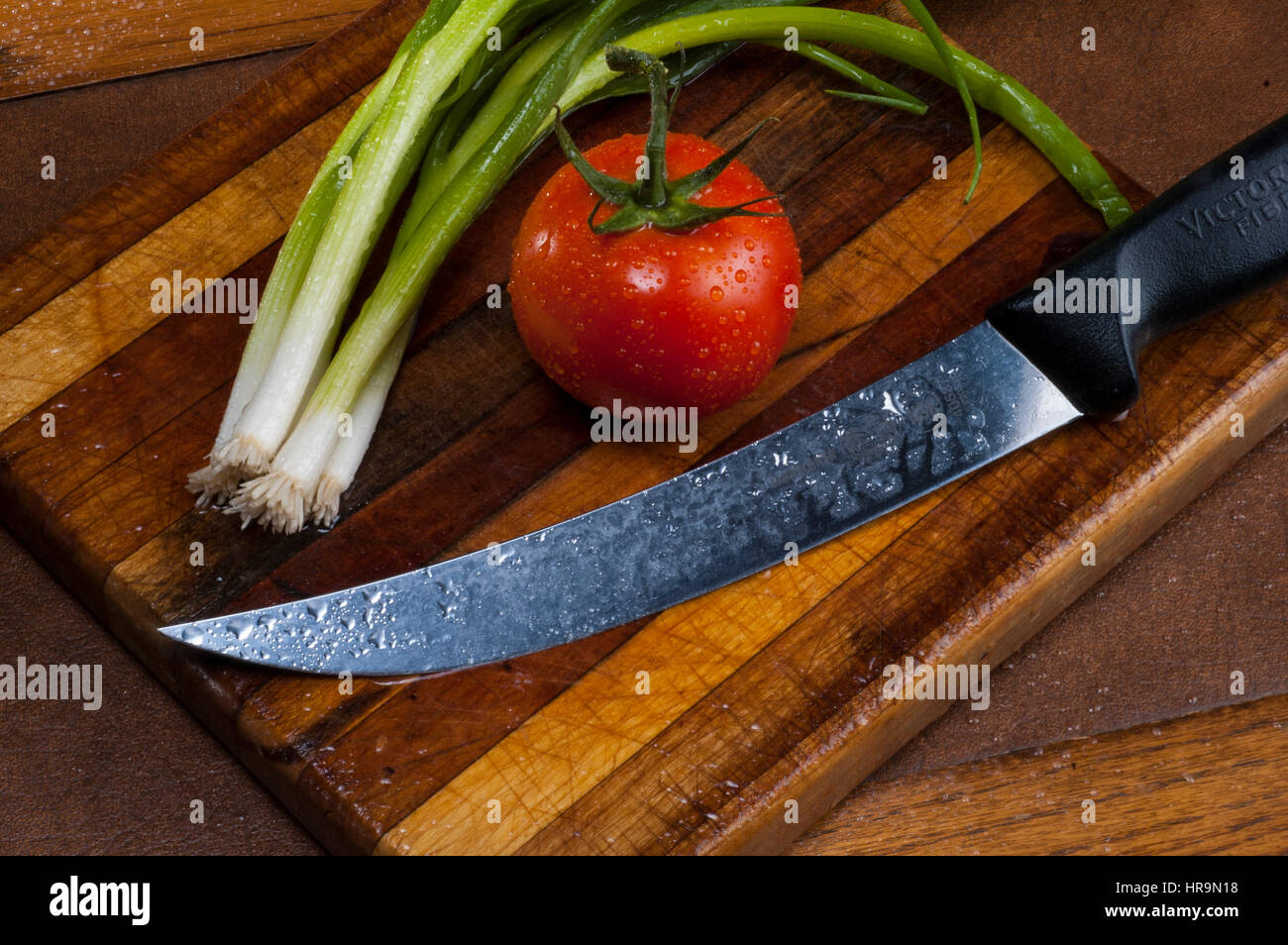 tomato and green onions on cutting board with knife Stock Photo - Alamy