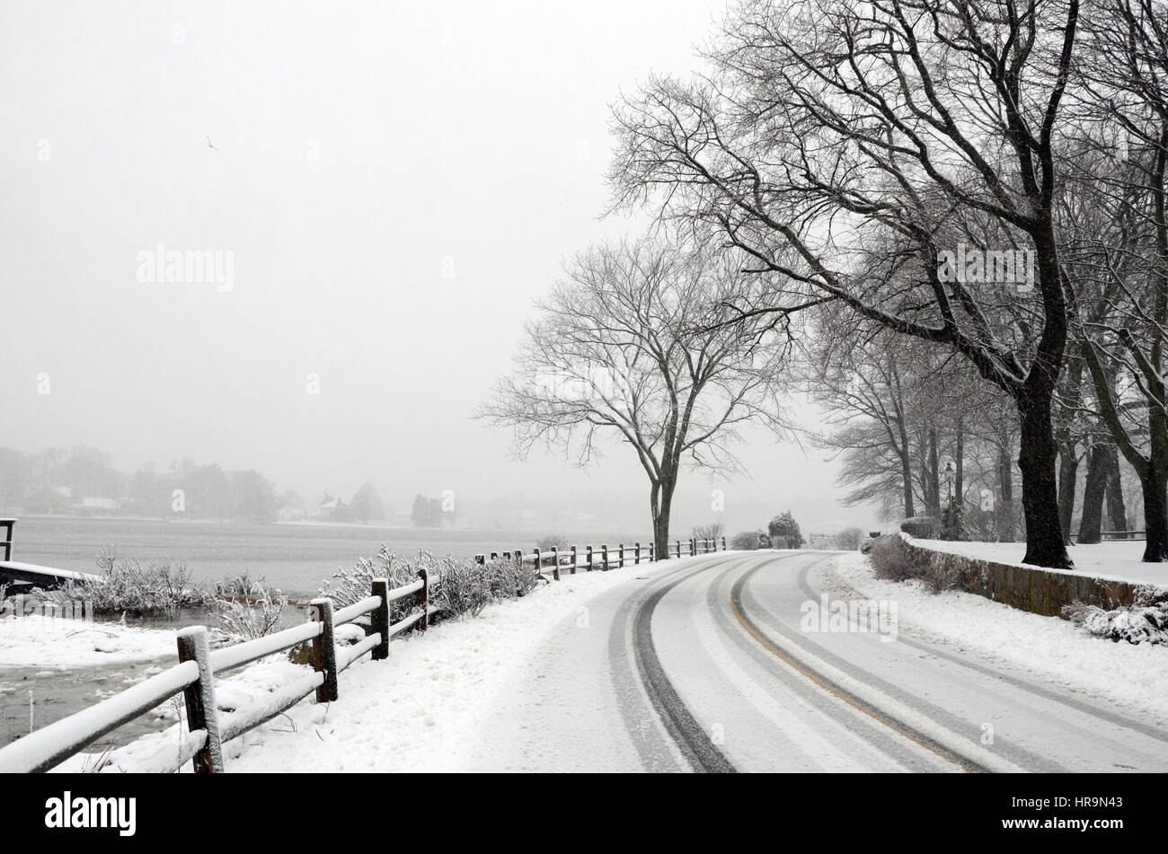 Snow covered road by the bay Stock Photo Alamy