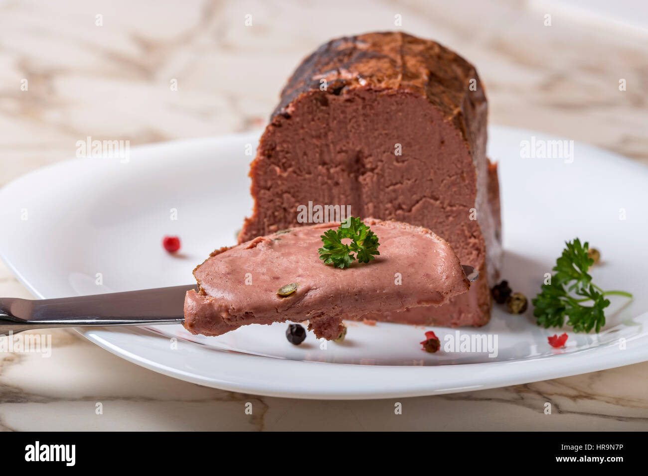 Special liver pate made from different types of meat with peppercorns on knife Stock Photo