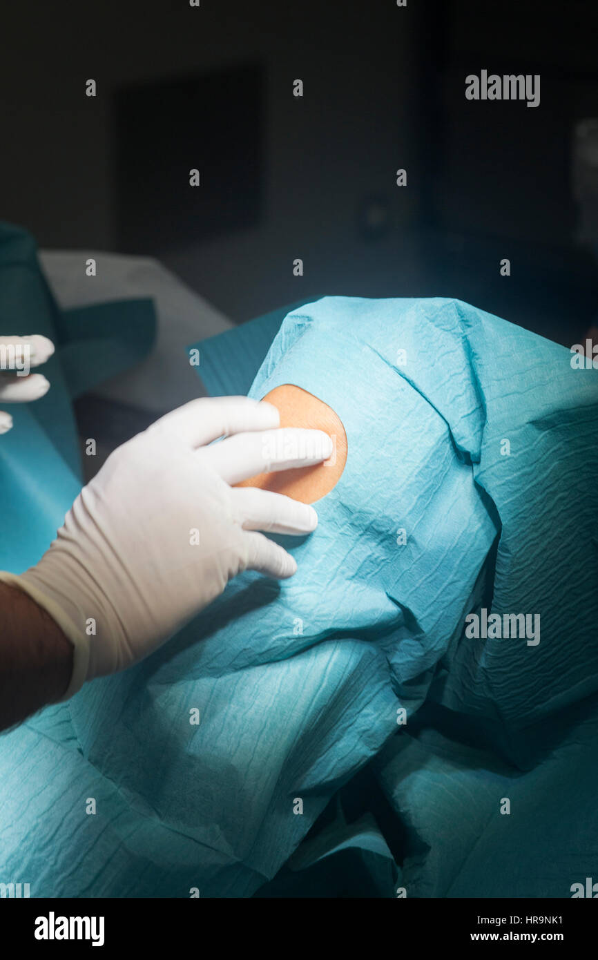 Preparing knee for surgery hospital operation medical procedure in emergency room operating theater. Stock Photo