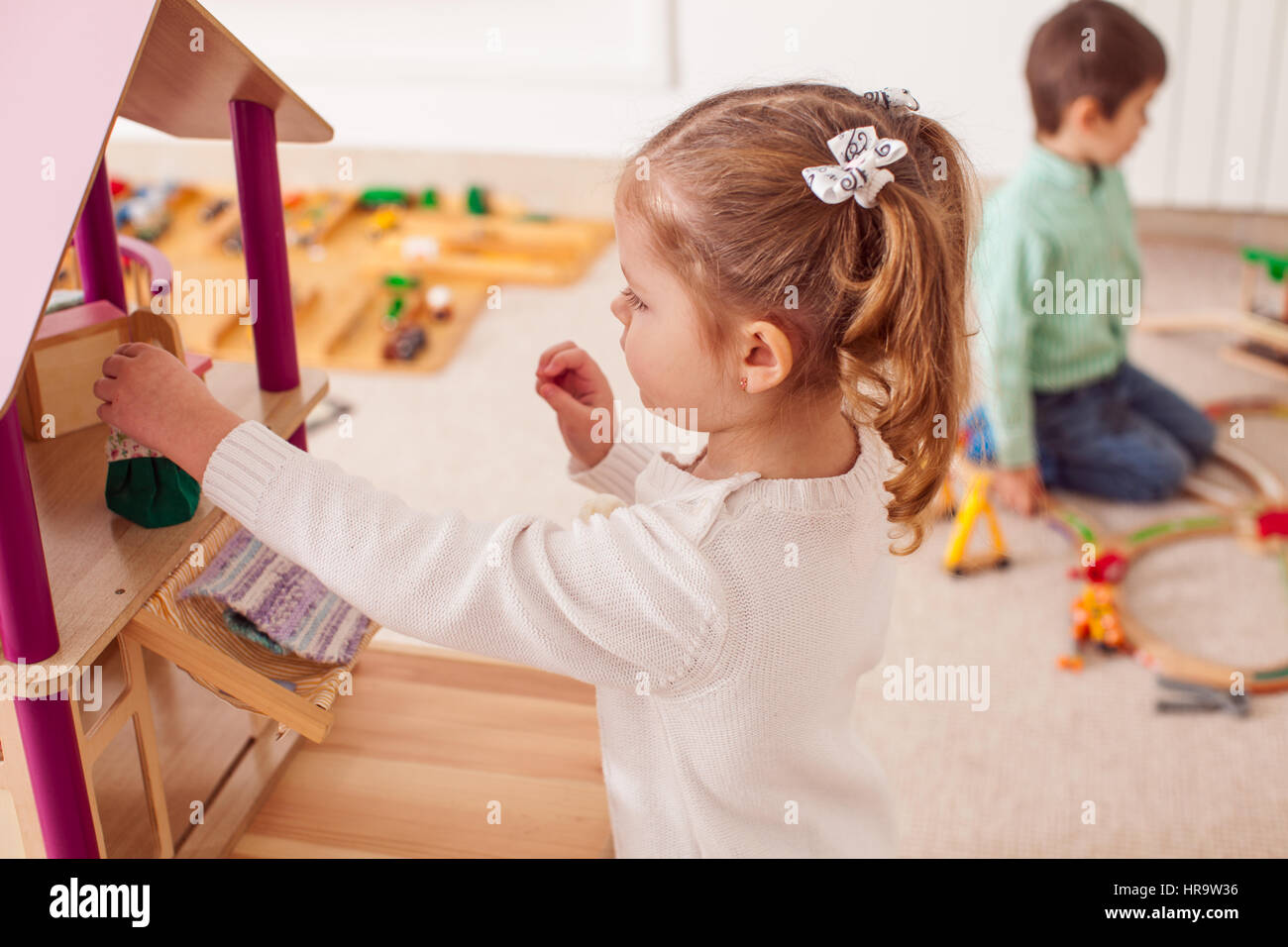 Girl playing with a dollhouse Stock Photo - Alamy