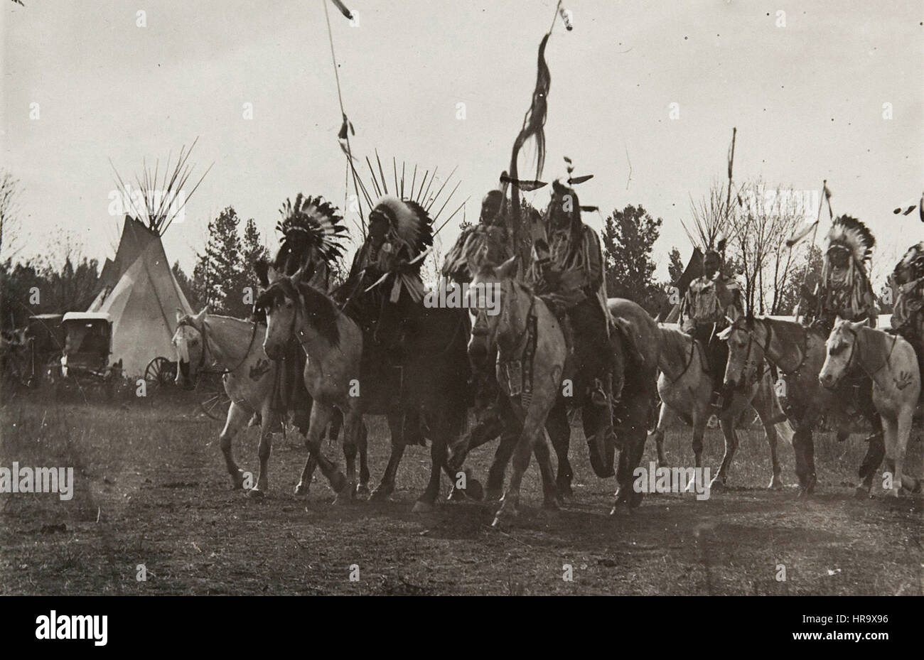 Untitled (Native Americans wearing headdresses on horseback) Stock Photo