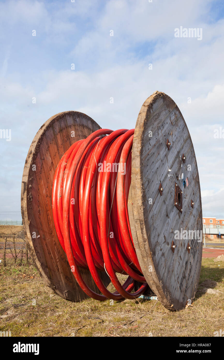 large wooden spool with heavy red underground cable Stock Photo