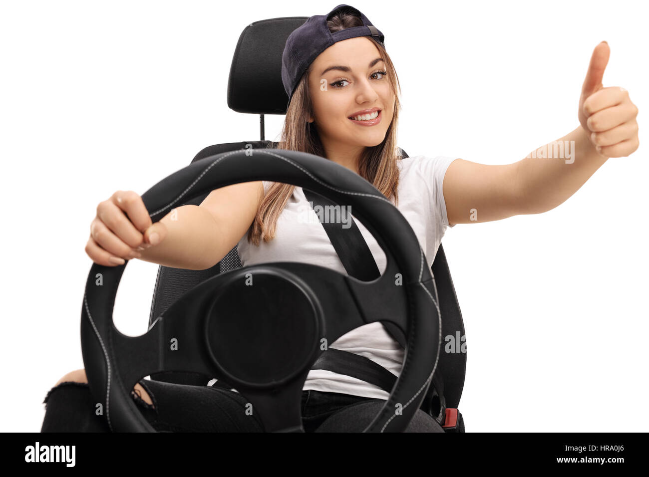 Joyful teenage girl sitting in a car seat and making a thumb up sign isolated on white background Stock Photo
