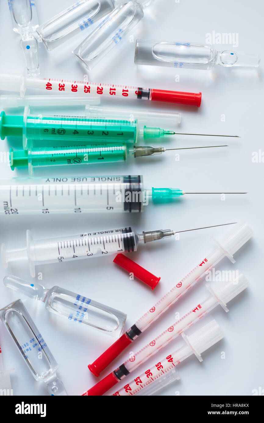 Plastic syringes with needles of different sizes and glass ampoules