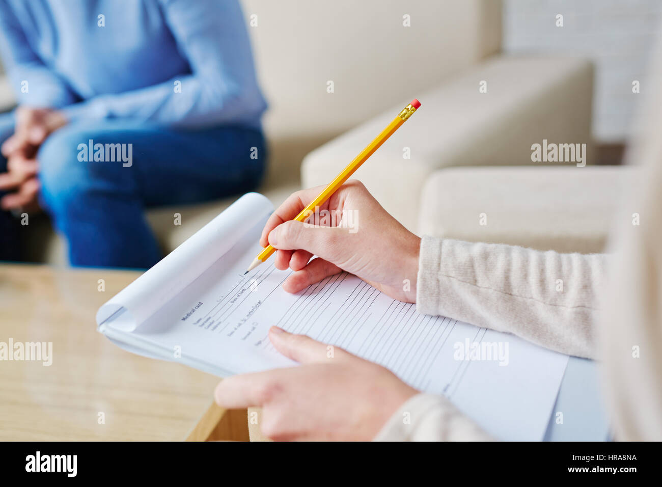 Psychologist in brown cardigan sitting on armchair and making diagnosis