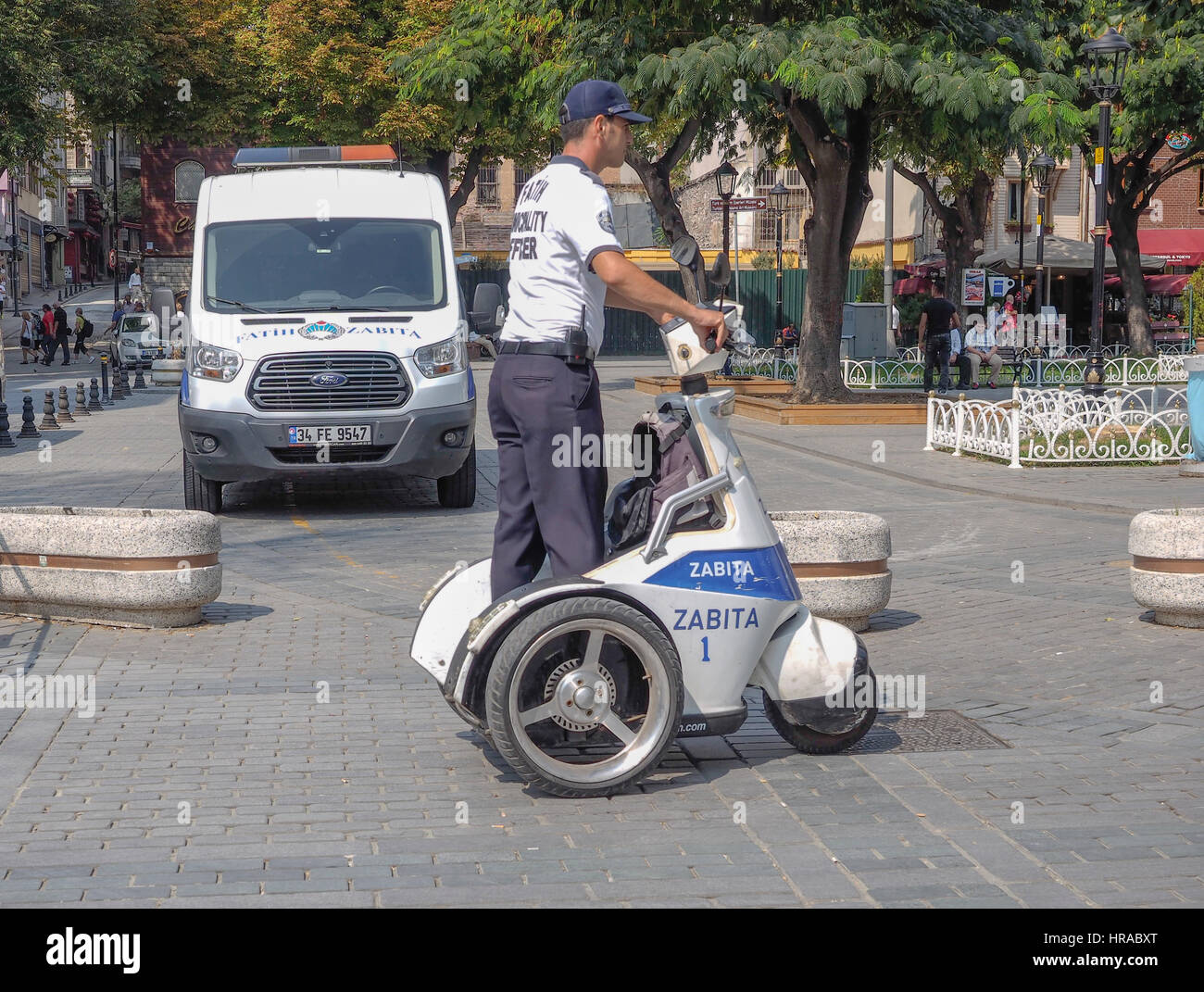 SECURITY OFFICER ON ELECTRICALLY POWERED THREE WHEEL SCOOTER ON PATROL