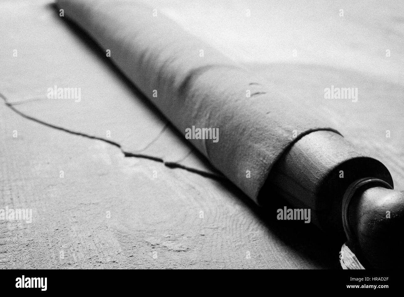 Close up of pasta dough wrapped around a wooden rolling pin Stock Photo