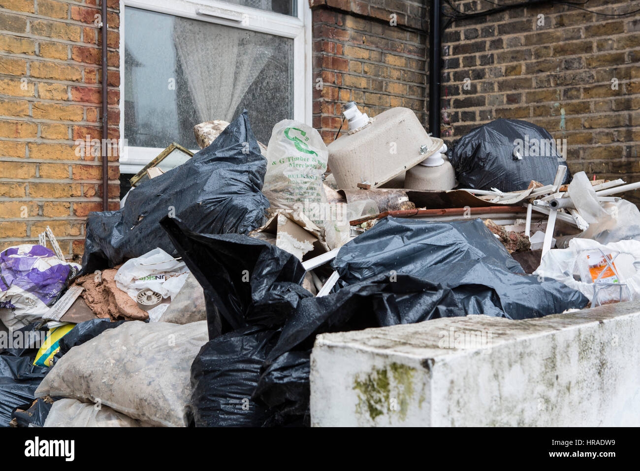 Piles of rubbish outside an old house as it is being cleared for