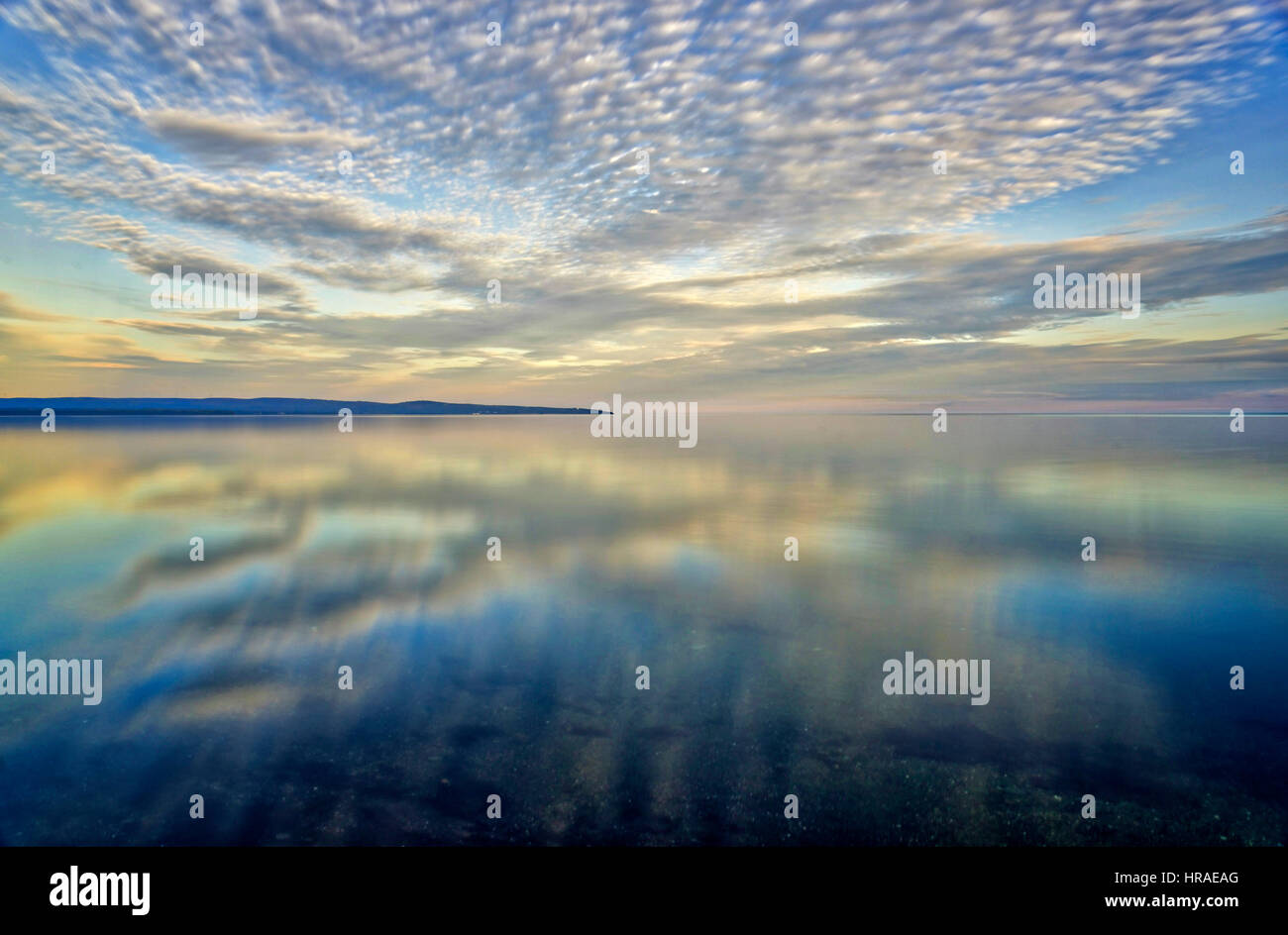 Gorgeous altocumulus clouds reflected in a nearly flat sea in Baie des Chaleurs, Gaspesie, Quebec Stock Photo