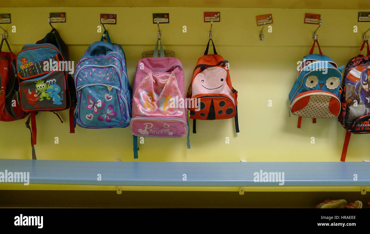 Childrens rucksacks hung on their pegs in a daycare Stock Photo