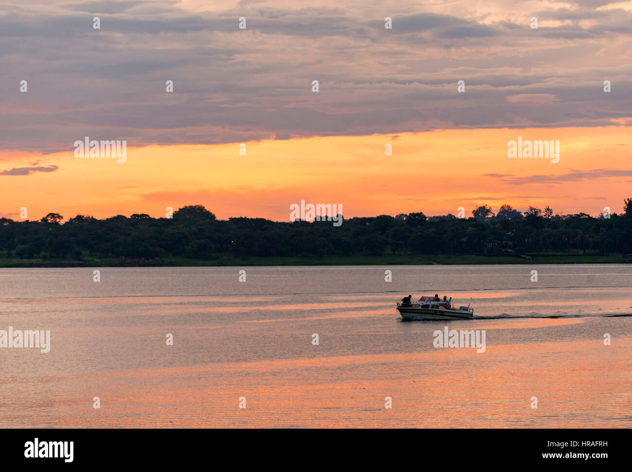 A speedboat enjoys a sunset cruise, Zimbabwe Stock Photo