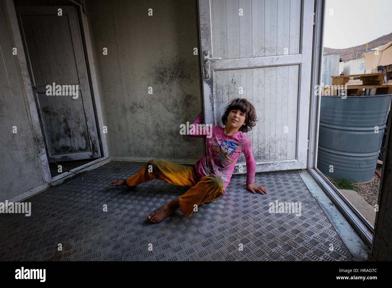 A mentally handicapped refugee girl age 9, chained to a toilet by the ankle in Zakho IDP camp near Dohuk, Kurdistan, Iraq. Stock Photo