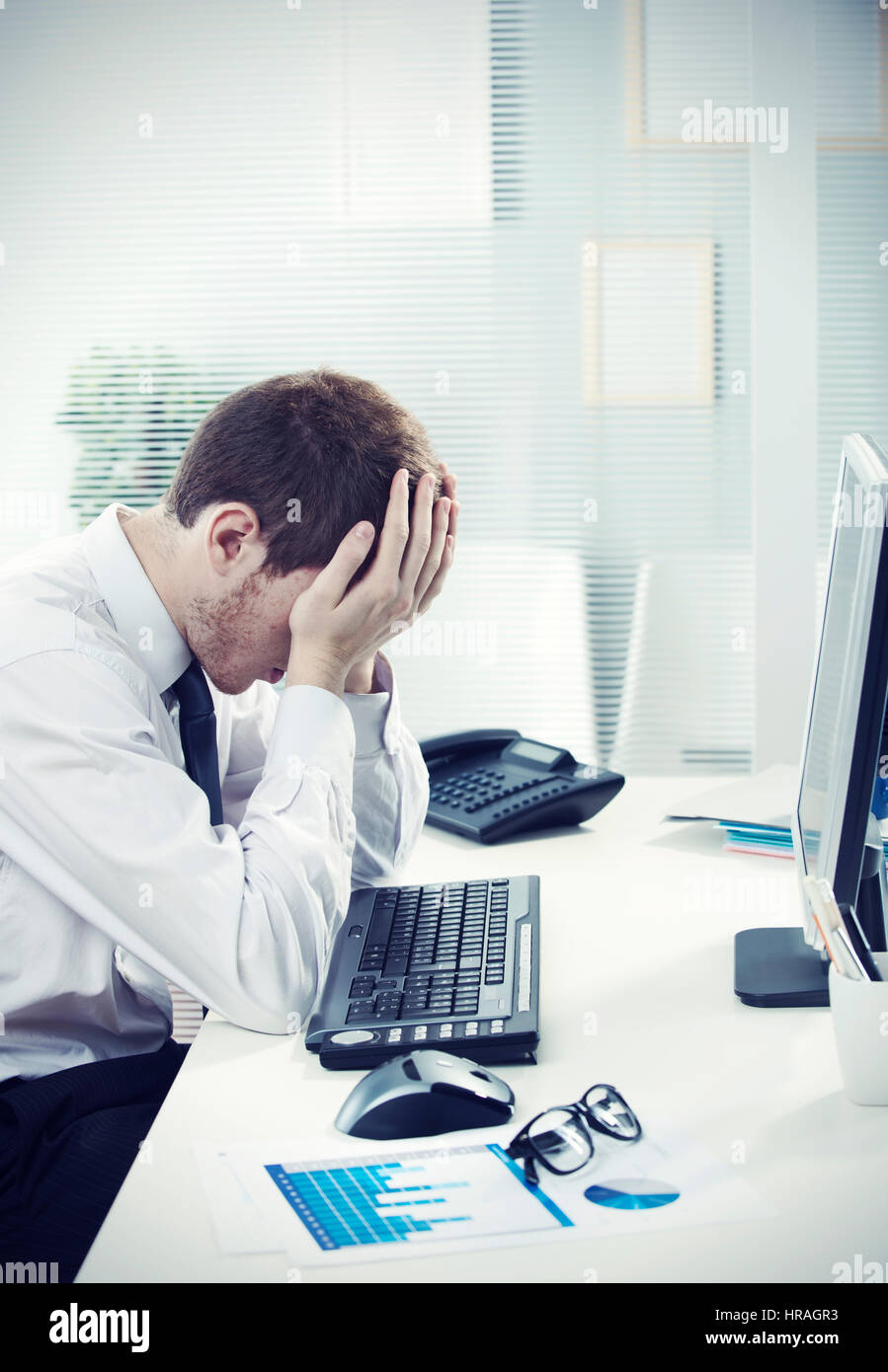A worried businessman sitting at office desk Stock Photo - Alamy