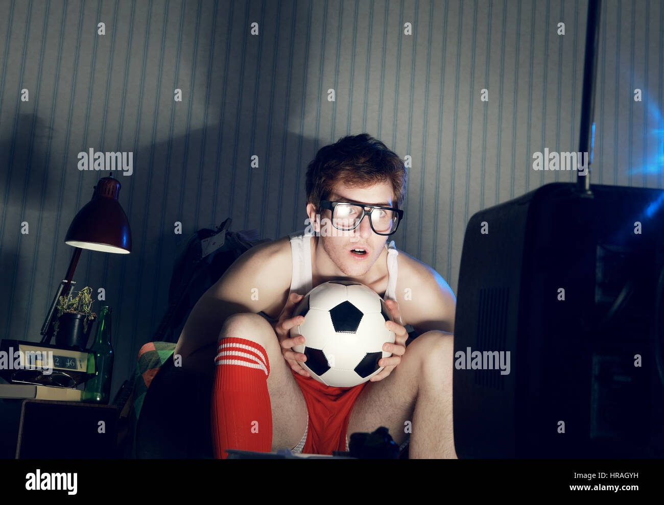 Young man soccer fanatic watching soccer match in television Stock Photo