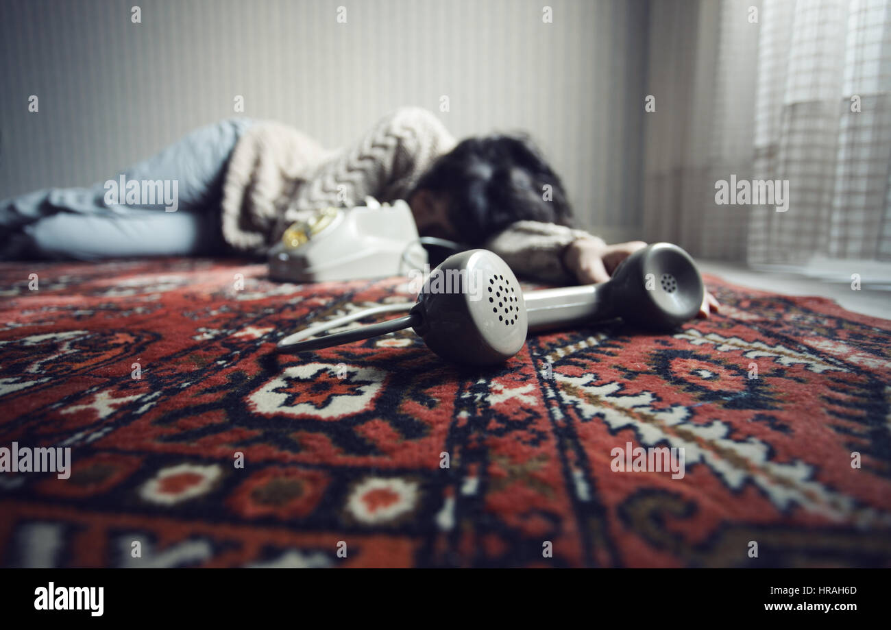 Dead woman on the floor, phone in the foreground Stock Photo