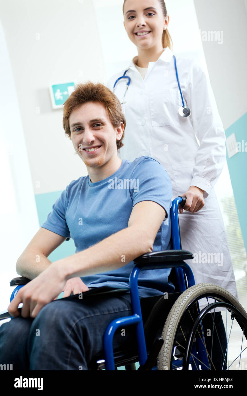 Female nurse pushing her patient on a wheelchair Stock Photo - Alamy
