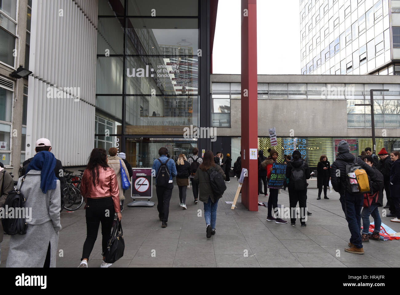 Students entering UAL: University Of The Arts while protesters are gathering outside the university for Stop-Trump & Stop-Brexit protest Stock Photo