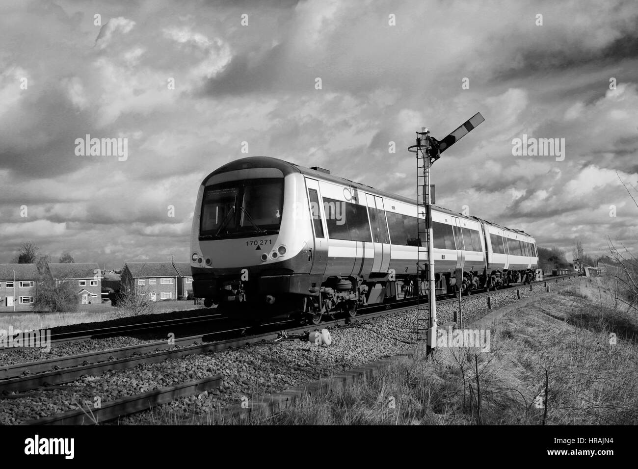 Abellio Greater Anglia, Turbostar 170271 passing an unmanned level crossing, Whittlesey town, Fenland, Cambridgeshire, England Stock Photo