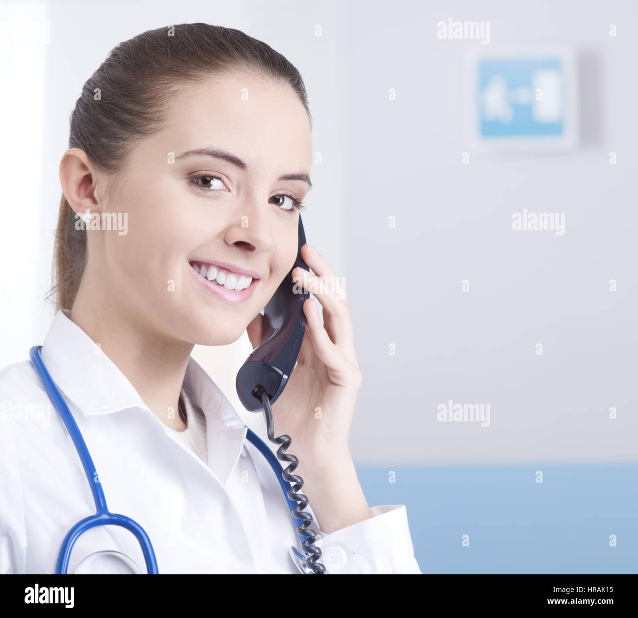 Young female doctor talking on the phone and smiling Stock Photo - Alamy