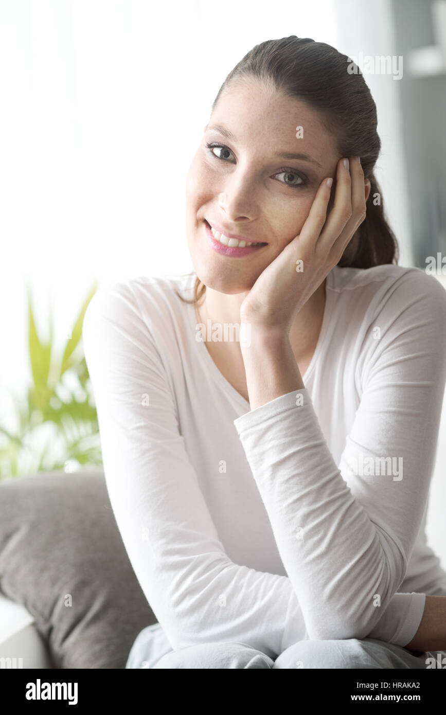 Attractive young woman relaxing on sofa in the living room Stock Photo ...
