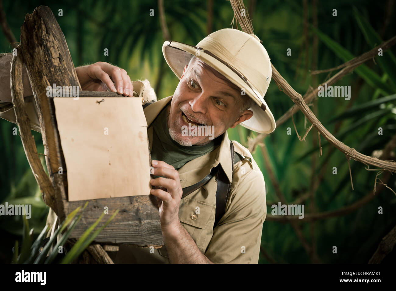 Cheerful explorer leaning to a sign in the forest Stock Photo - Alamy