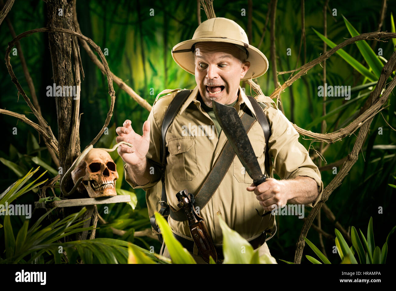 Shocked adventurer finding a human skull in the jungle with retro colonial style equipment. Stock Photo