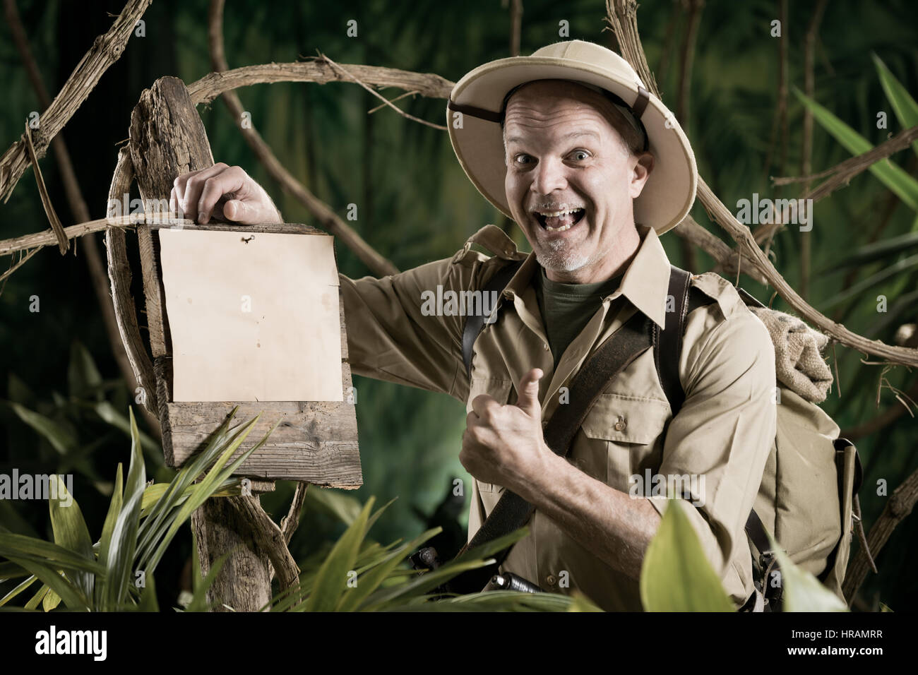 Cheerful explorer thumbs up leaning to a sign in the forest Stock Photo ...
