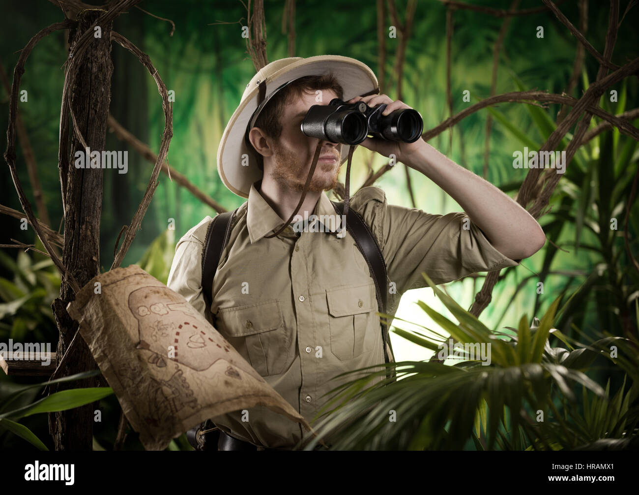 Expert explorer in the jungle looking away through binoculars Stock Photo -  Alamy