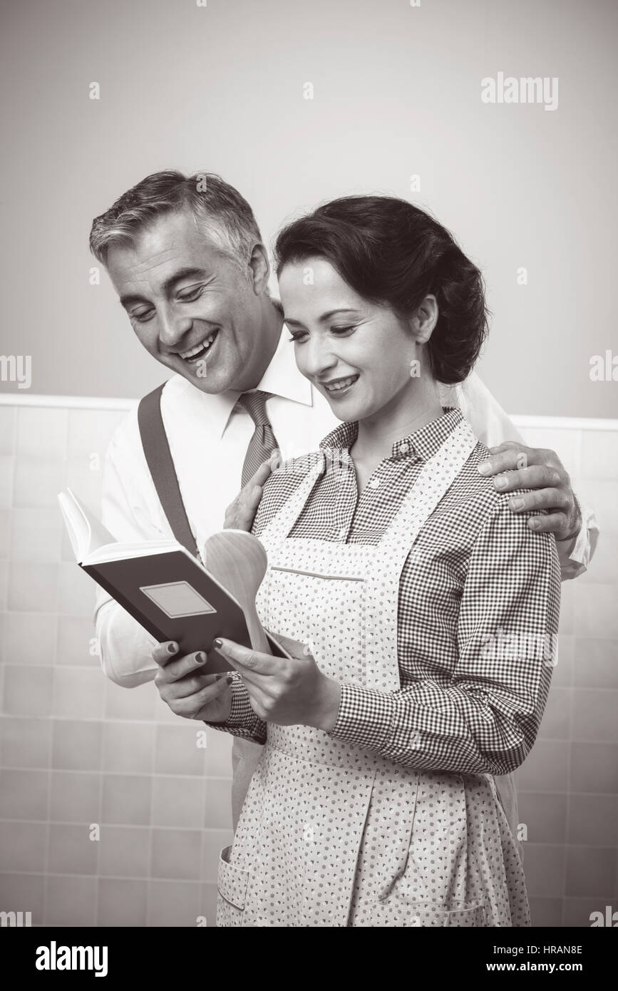 Vintage wife and husband reading a cookbook together at home Stock ...