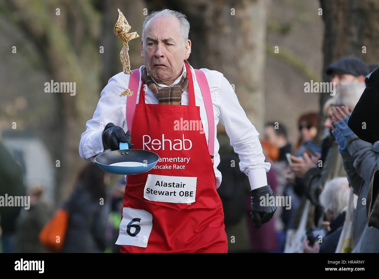 London, UK. 28th Feb, 2017. Television presenter Alastair Stewart takes part in the Rehab Parliamentary Pancake Race in Victoria Tower Gardens, in London, Britain on Feb. 28, 2017. The annual race held on Shrove Tuesday is a relay between MPs, Lords and the media, and raises money for the Rehab disability charity. Credit: Tim Ireland/Xinhua/Alamy Live News Stock Photo