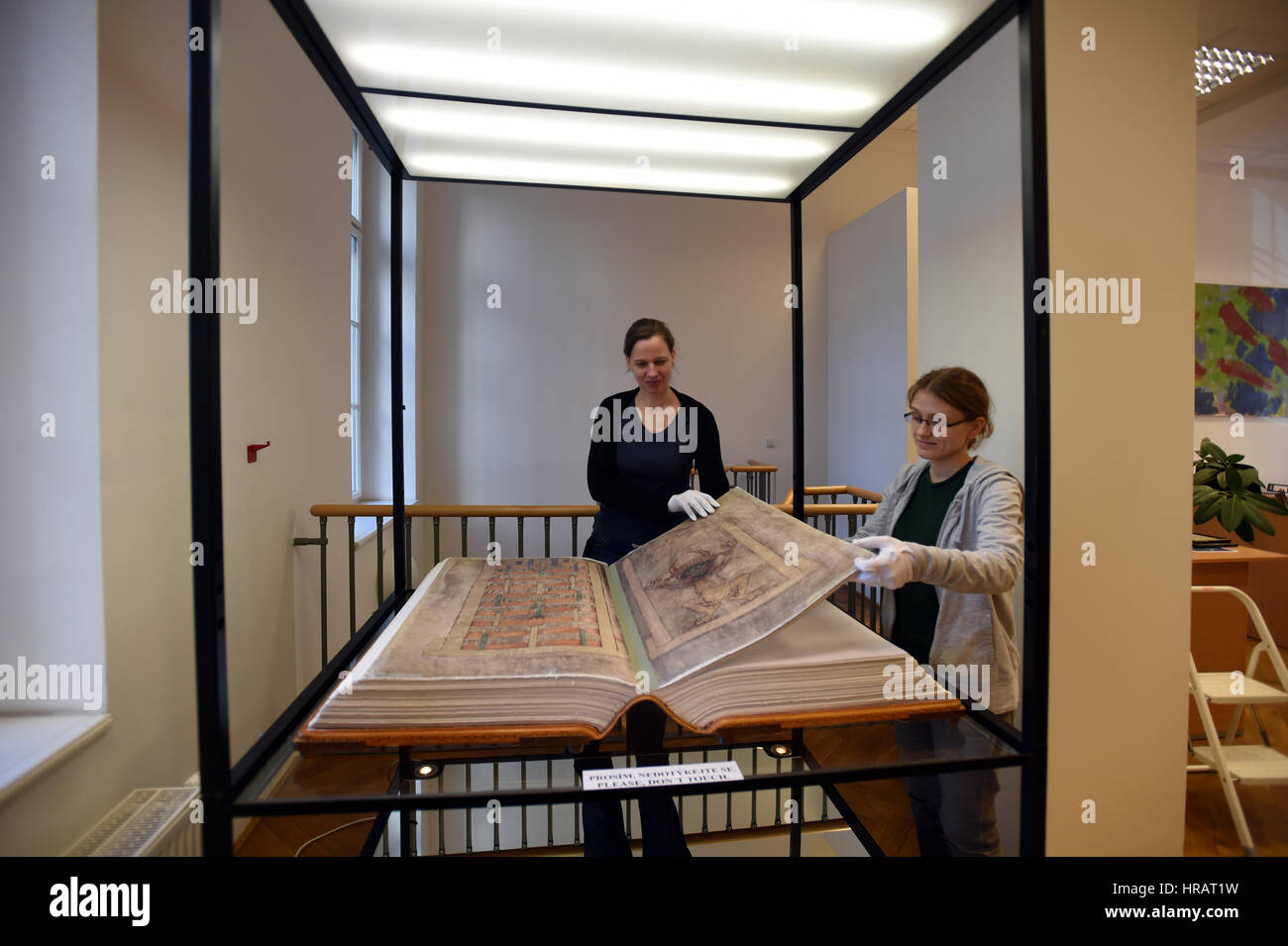 Librarians Ludmila Netusilova, left, and Martina Vodakova adjust facsimile of the Devil´s Bible (Codex Gigas) exhibited Municipal Museum of Usti nad Labem, Czech Republic, February 27, 2017. The Devil's Bible, (89, 5 x 49 cm, weighs 75 kg), contains the Old and New Testaments in pre-Vulgate Latin translations, Josephus' History of the Jews in a Latin translation, the Chronicle of Bohemia, written by Cosmas of Prague, etc. The manuscript was written in the early 13th century in the Benedictine monastery of Podlazice in Bohemia, the vellum used having been prepared from the skins of 160 asses. I Stock Photo