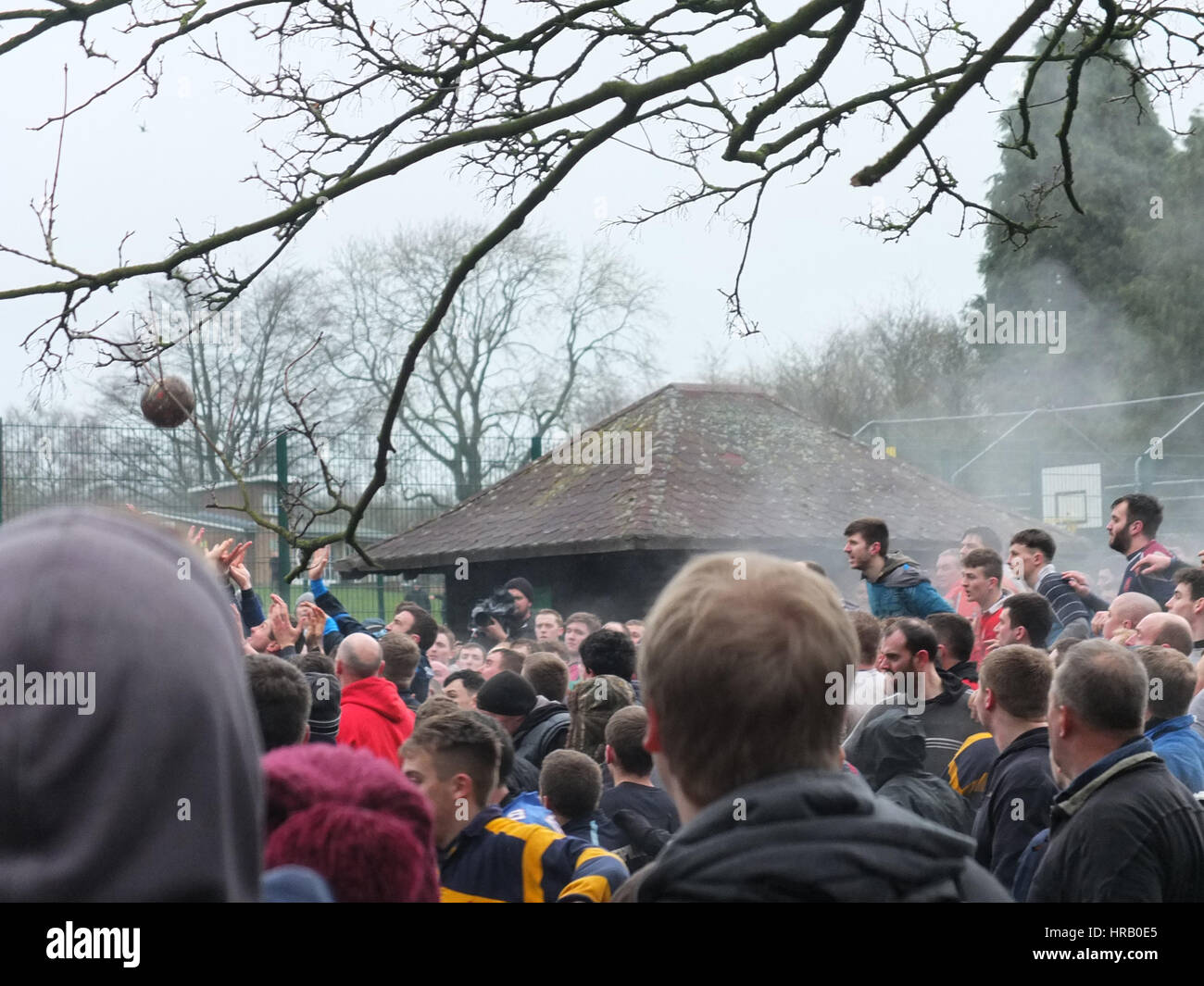 Ashbourne, Derbyshire, UK. The annual rumble between the Uppards and Downards that is Ashbourne Royal Shrovetide Footabll taking place. Essentially a giant rugby scrum that takes place over the whole town, players have to goal the ball at one of two goals and which team you play for depends on whether you were born upwards or downwards of the Henmore Brook which flocks through the town. The whole thing takes place again tomorrow (1st March), Ash Wednesday. The ball to extreme left of photo. Stock Photo