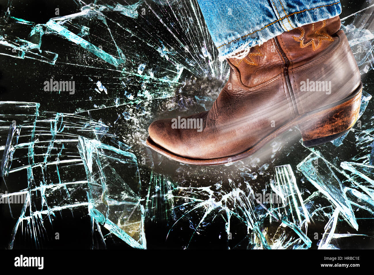 Western cowboy boots kicking and stomping shattered glass. Stock Photo
