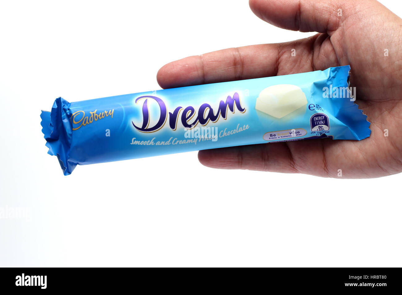 Hand holding Australia Cadbury white chocolate bar isolated against white background Stock Photo
