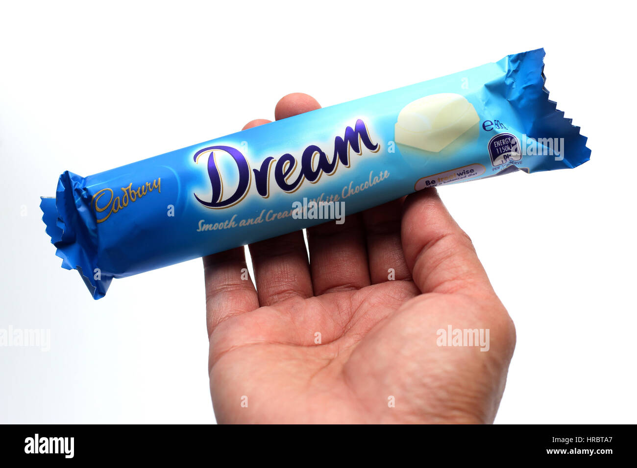 Hand holding Australia Cadbury white chocolate bar isolated against white background Stock Photo